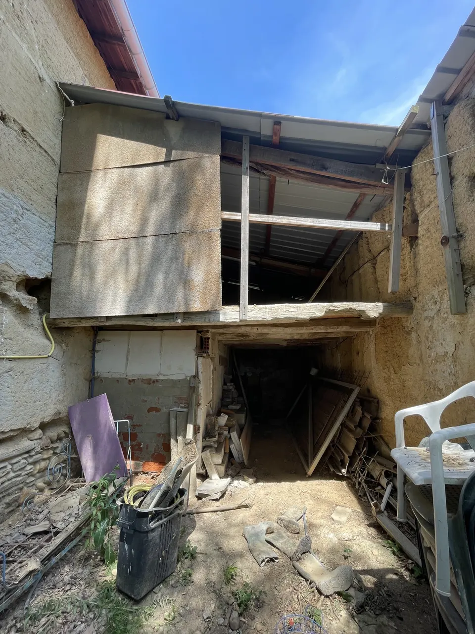 La cour avant travaux, encombrée de gravats et de mobilier.