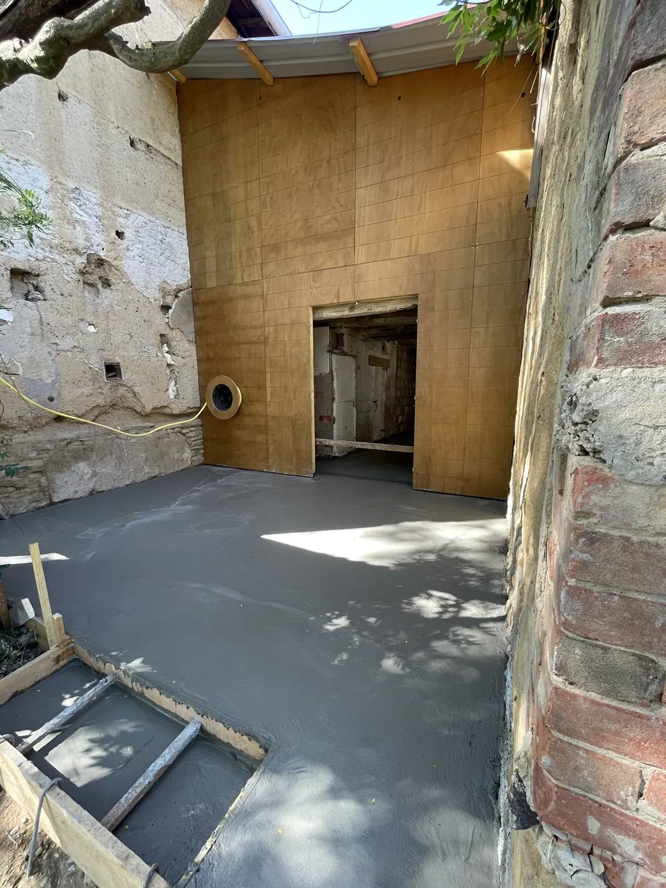 La dalle en béton coulée devant la cloison en bois.