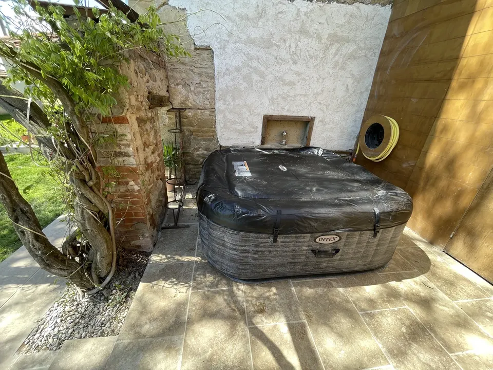 Le spa installé sur le carrelage, sous la glycine.