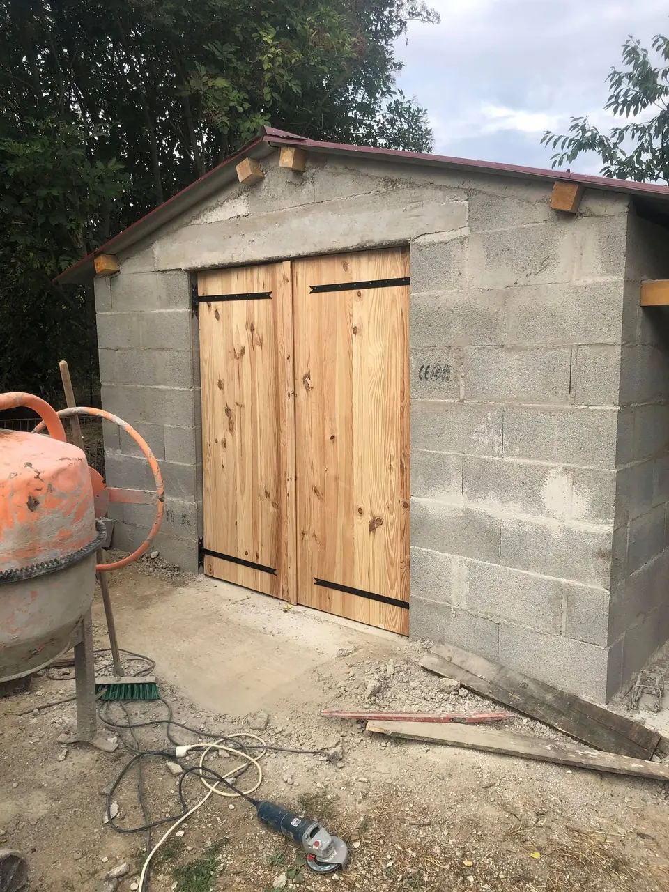 Grandes portes en bois à double battant posées, état le plus abouti du chantier.