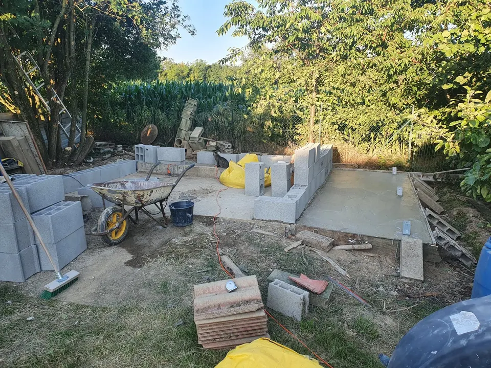 Dalle béton coulée et premiers rangs de parpaings.