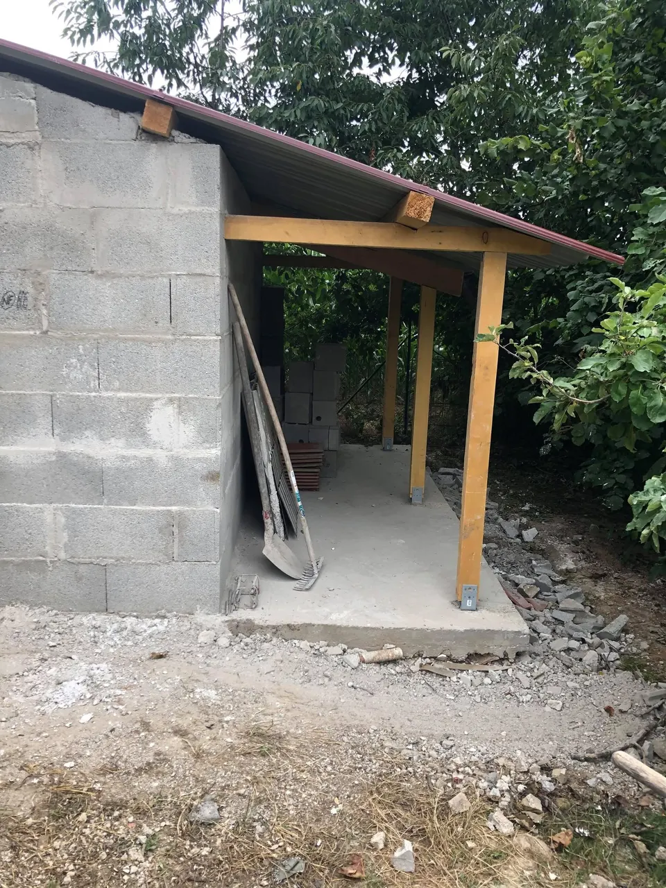 Création de l'auvent latéral sur poteaux en bois.