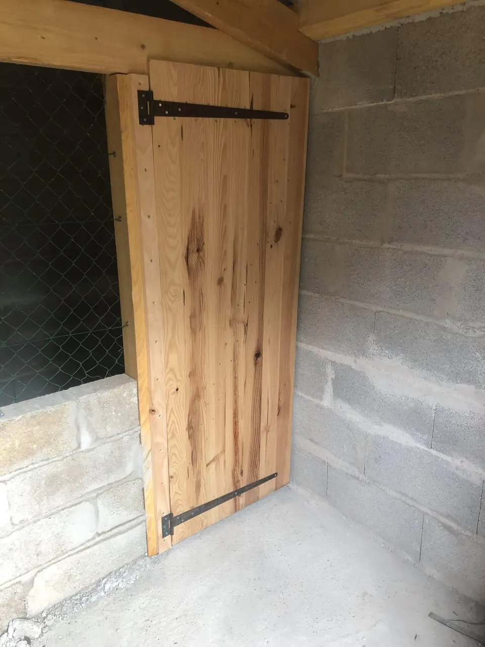 Porte intérieure en bois et grillage.