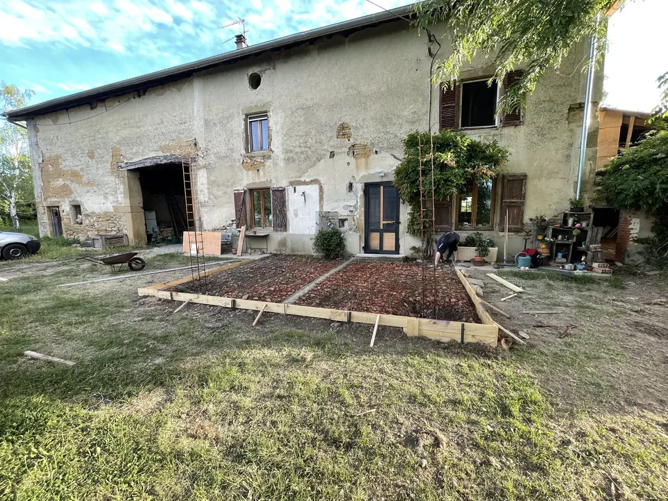 Coffrage en bois et ferraillage de la future dalle devant la façade.