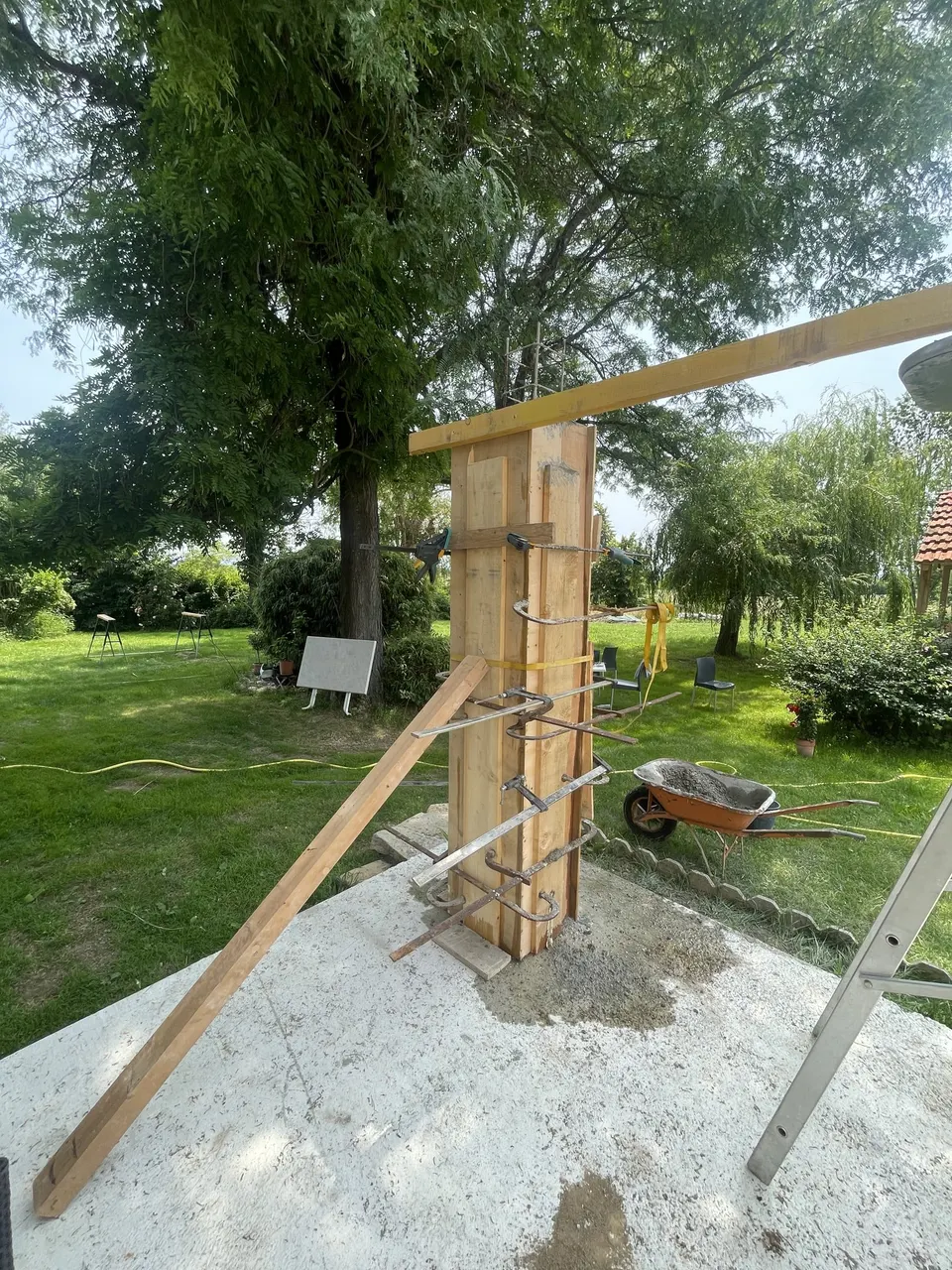 Poteau coffré en bois sur la dalle, première poutre posée au sommet.