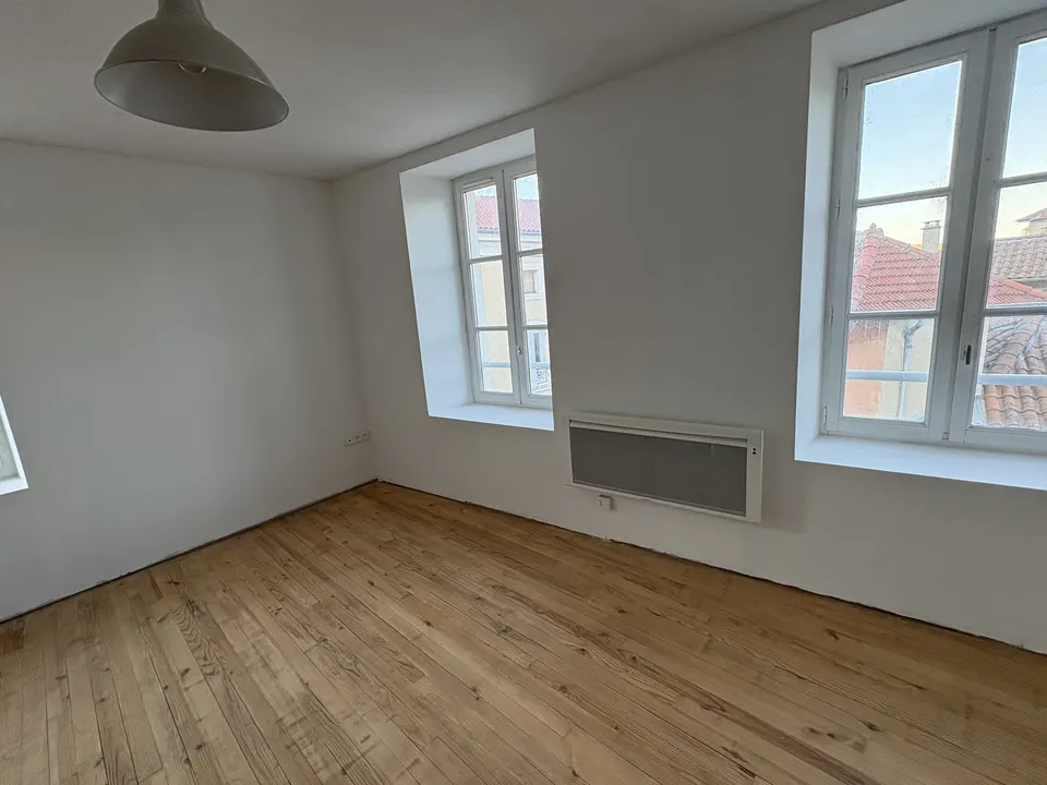 La pièce terminée : murs blancs et parquet en bois, lumineuse et dégagée.