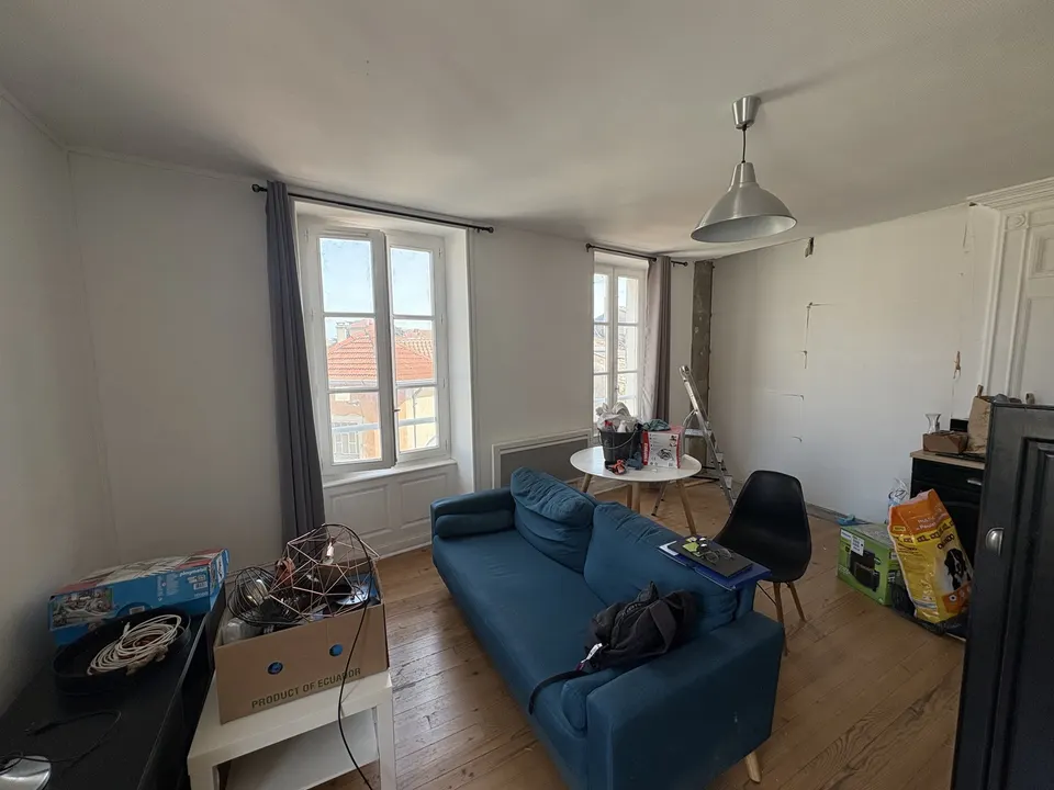Avant les travaux : le séjour, avec ses fenêtres à persiennes et son parquet.