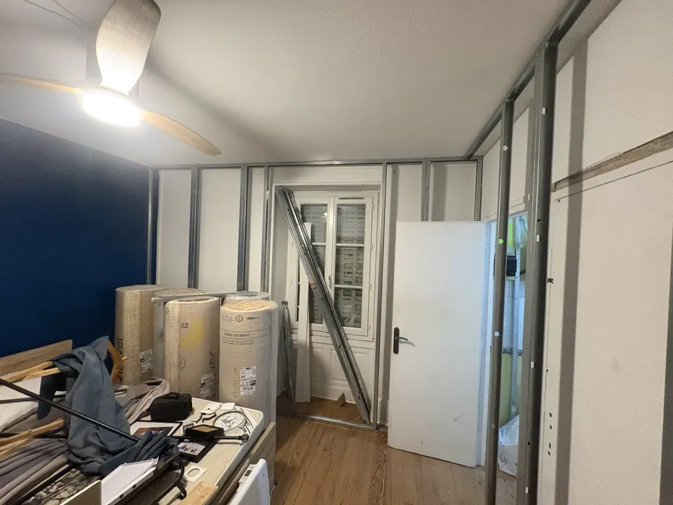 Les rails et montants métalliques dessinent la future cloison de la chambre.