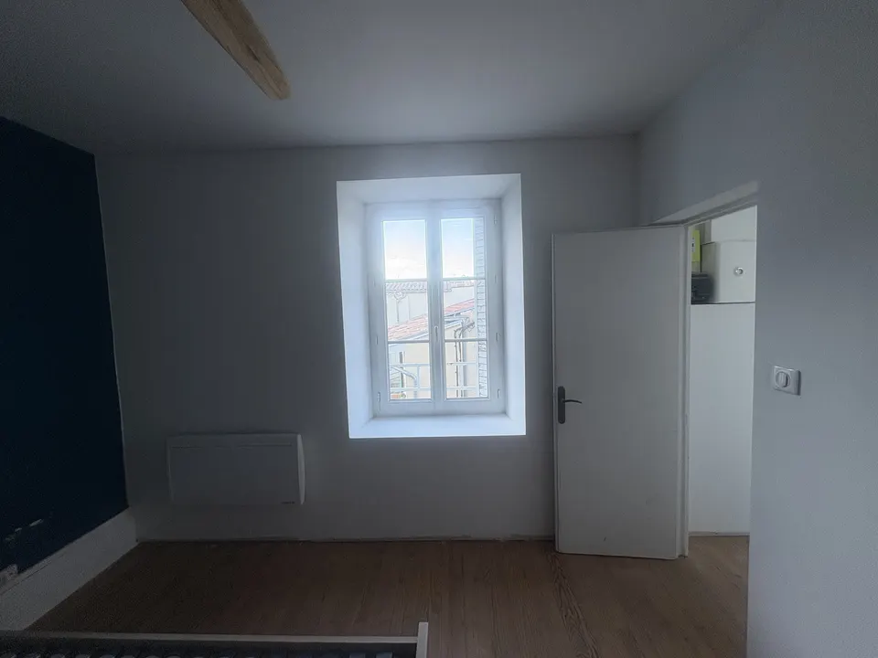 La chambre en fin de chantier : murs clairs, porte et fenêtre dégagées.