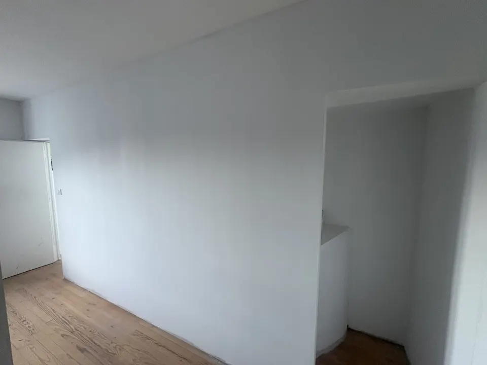 Le même mur qu'avant les travaux, désormais lisse et peint en blanc.
