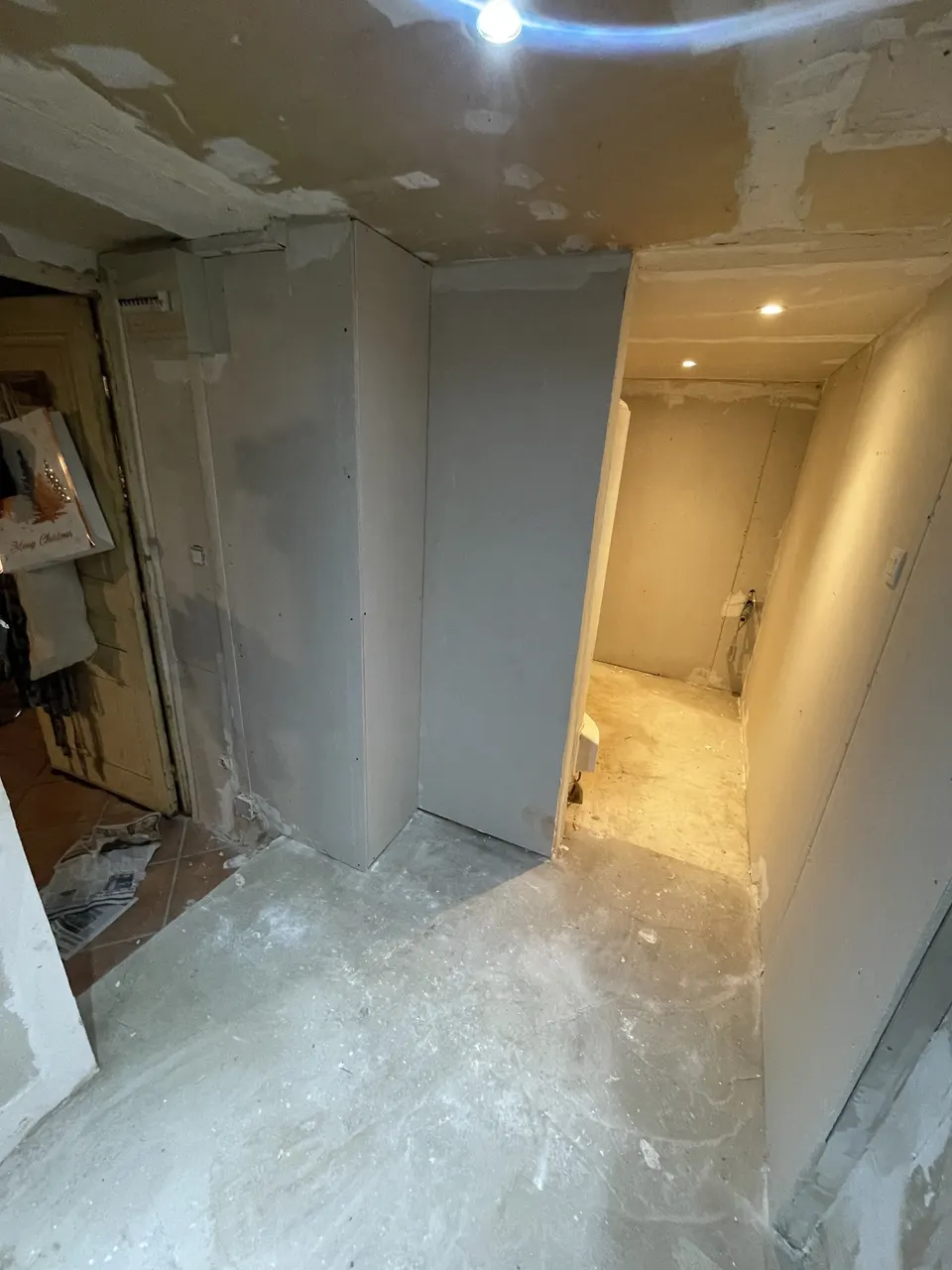 Cloisons enduites et spots posés dans le couloir menant aux toilettes