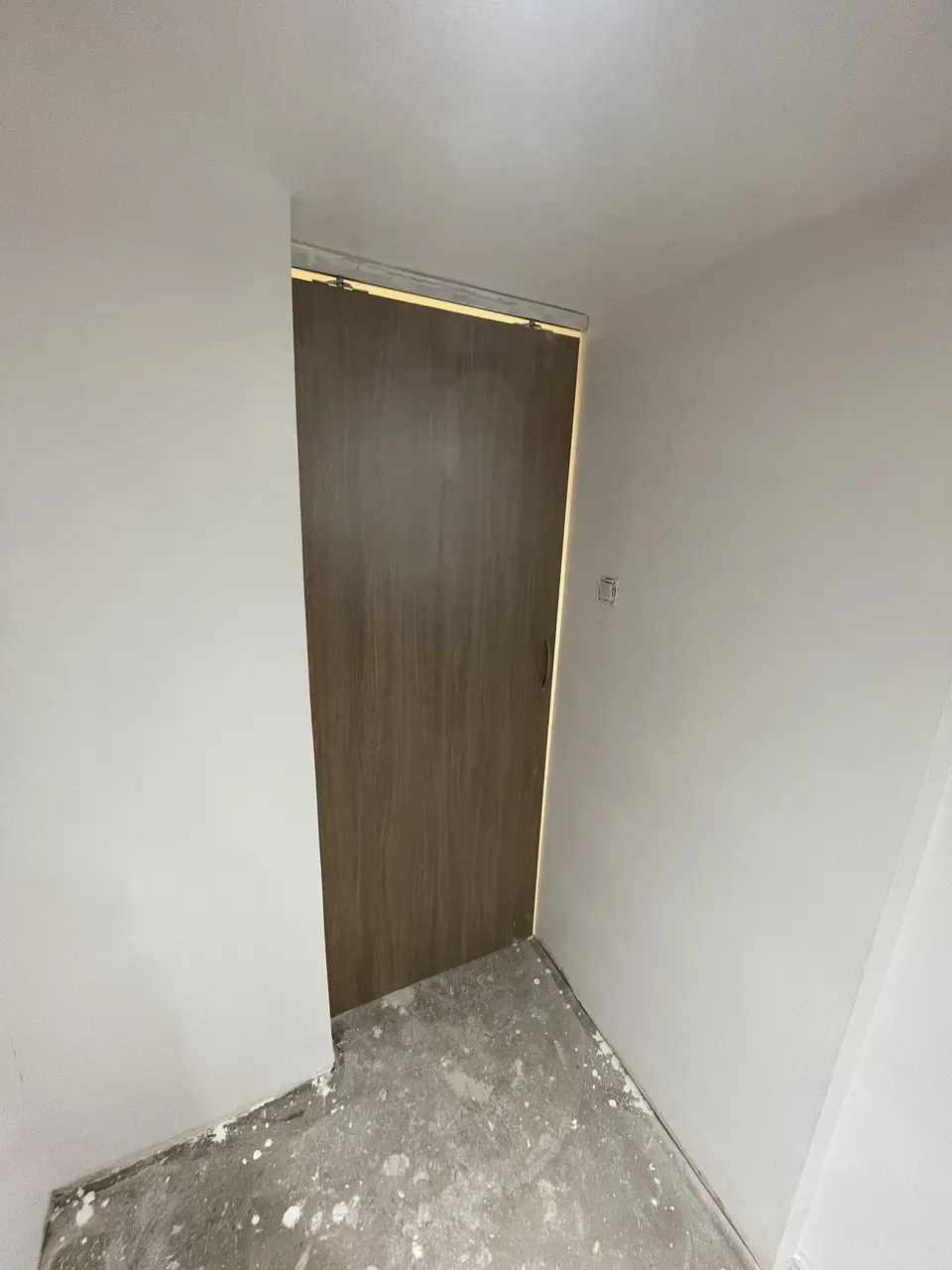 Porte coulissante en bois posée devant l'accès aux toilettes