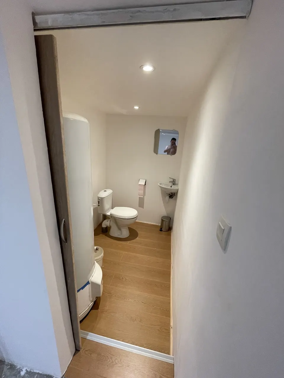 Toilettes terminées vues depuis le couloir, parquet stratifié posé