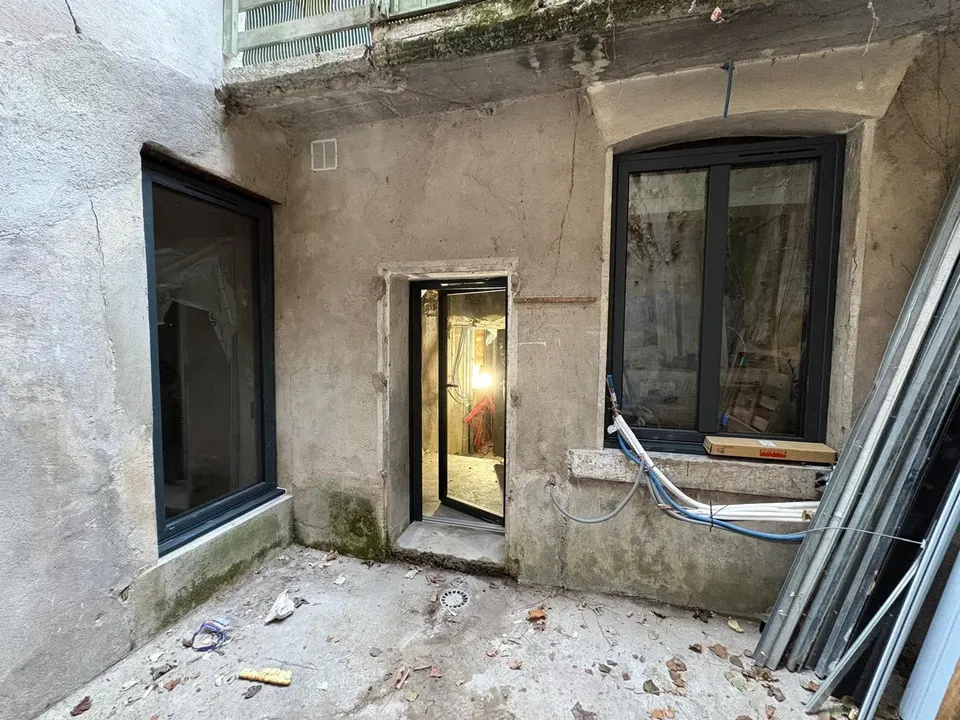 Les baies vitrées sont posées, la façade est encore brute et le chantier en cours.