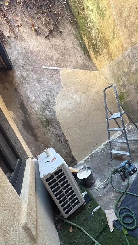 Préparation des murs : l'enduit est appliqué, échelle et outils sur place.