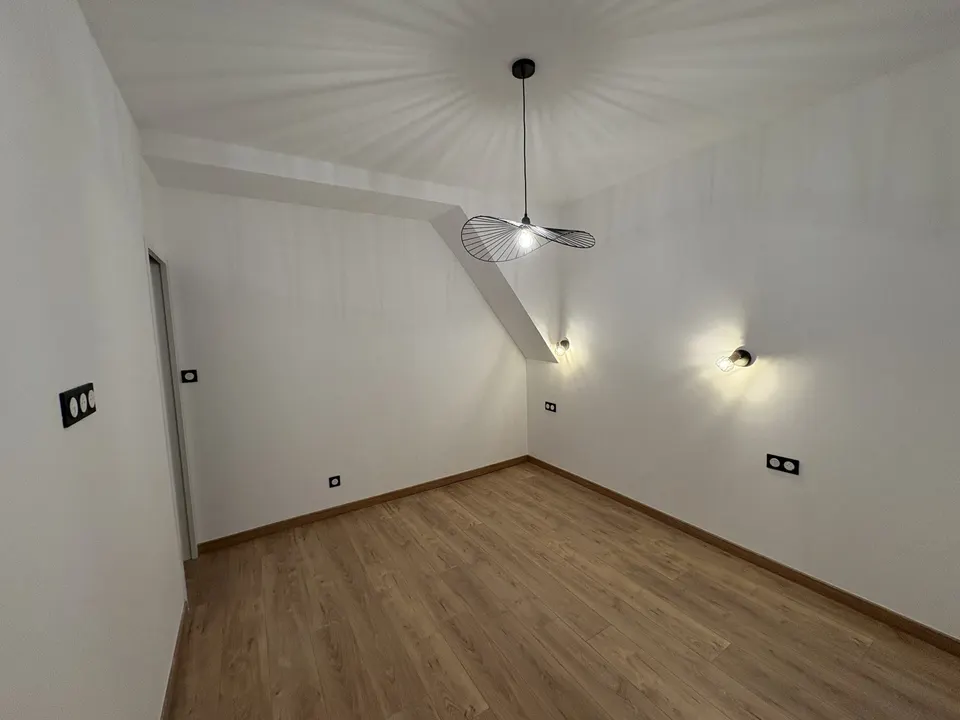 Chambre terminée : parquet stratifié, plinthes, suspension et appliques.