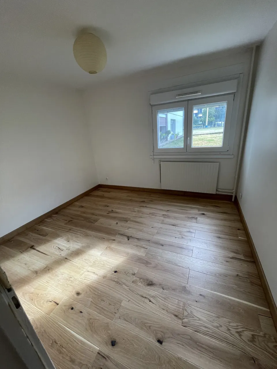 Pièce terminée : parquet en chêne posé, fenêtre et radiateur