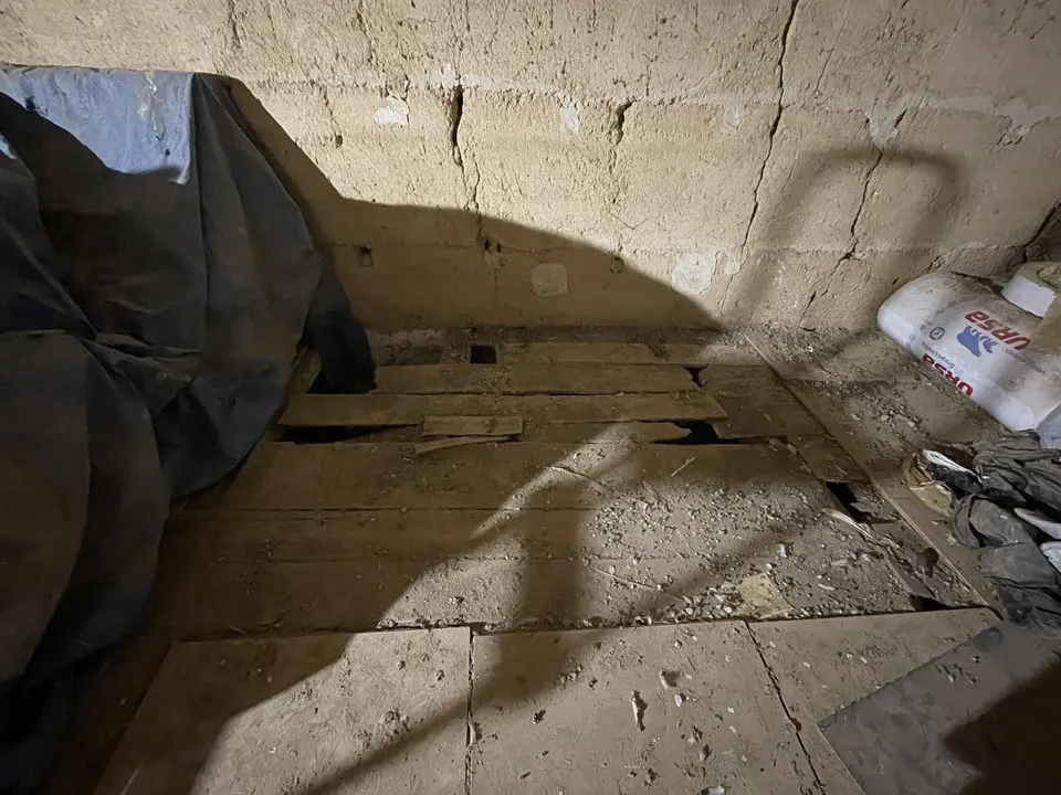 État de départ : ancien plancher en planches abîmé, bâche et sacs au sol.