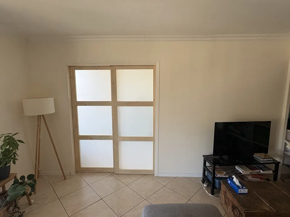 Porte à galandage fermée dans la cloison repeinte, finition terminée