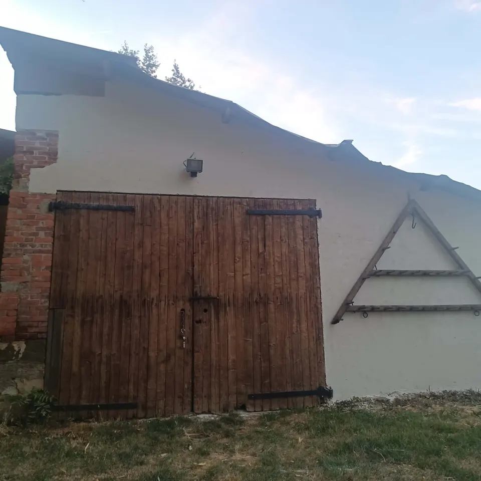 Grande porte de grange à deux battants en bois verni, ferrures noires