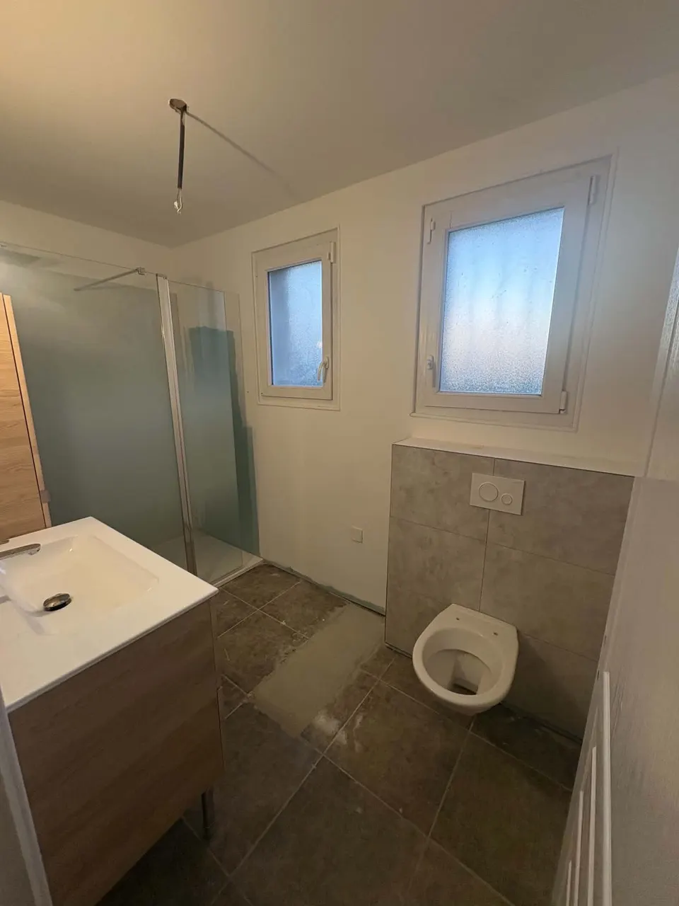 Meuble vasque en place, WC suspendu posé et carrelage en cours de pose