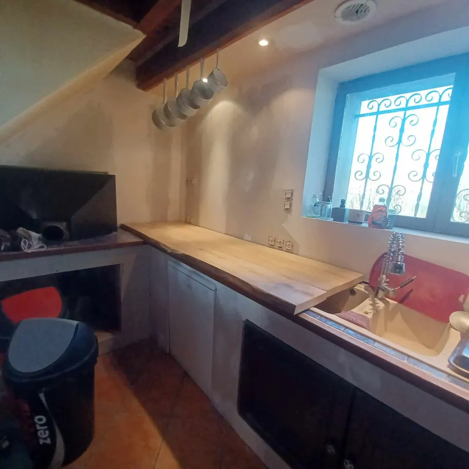 En cours de chantier : plan de travail en bois posé, murs encore bruts.