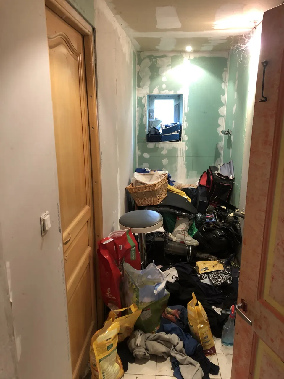 Placo hydrofuge en cours d'enduit, pièce encore encombrée d'outils et de sacs