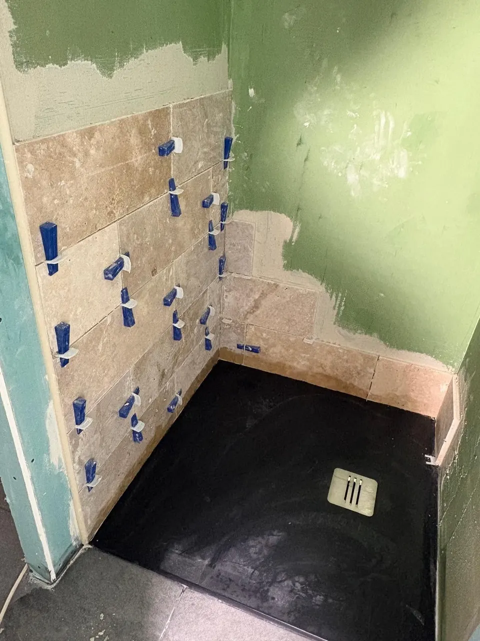 Début de la pose du travertin sur les murs de douche