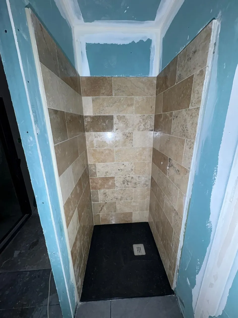 Murs de douche en travertin posés, avant les joints