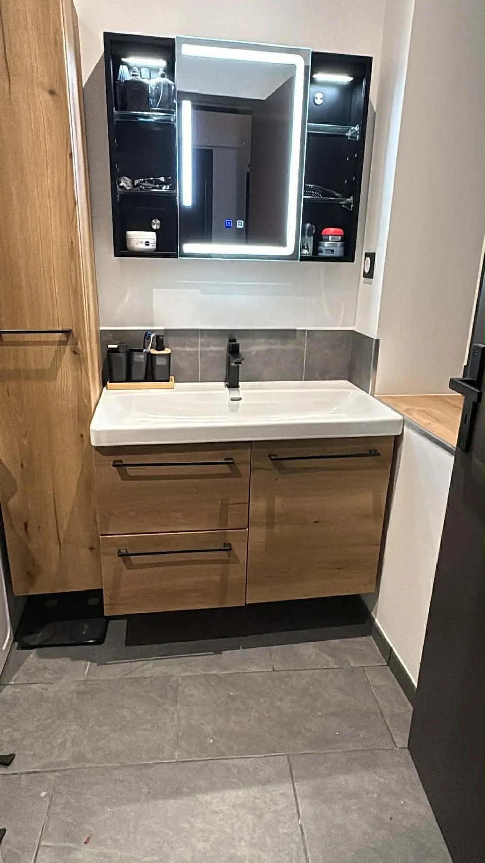 Meuble vasque en chêne, miroir lumineux et sol en carrelage gris