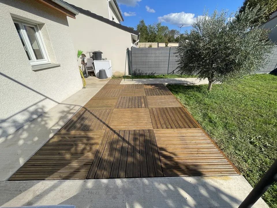 La terrasse en bois terminée, le long de la façade et de l'olivier